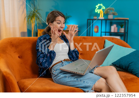 Surprised woman using laptop, receive good news shocked by sudden victory celebrate jackpot win 122357954