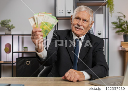Rich senior businessman working on laptop counting money cash, calculate earnings at home office 122357980