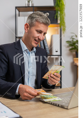 Upset businessman freelancer counting euro cash insufficient amount of money at home office desk 122357989