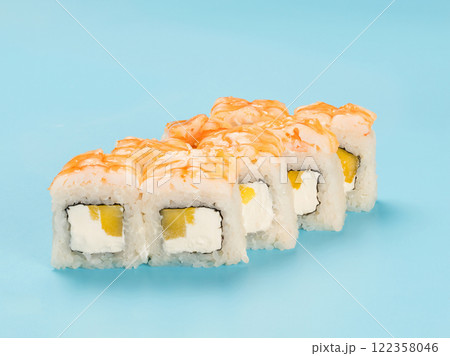 Studio photography of Philadelphia Roll of velvety cream cheese and mango wrapped in perfect seasoned sushi rice and fresh shrimp. Isolated on solid light blue background 122358046