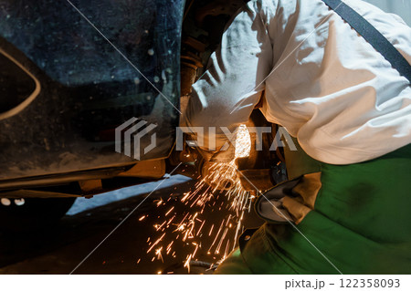 A Mechanic Working on a Car Suspension with Sparks Flying A Mechanic Working on a Car Suspension with Sparks Flying 122358093