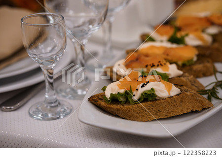 Appetizing Open-Faced Sandwiches with Smoked Salmon and Garnishes on a Table Setting 122358223