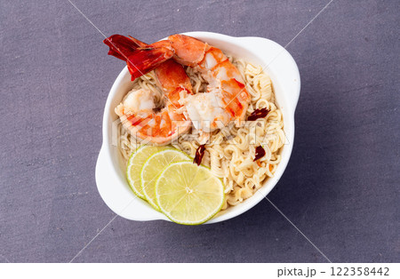 Tom yum soup with shrimps instant noodles and lime photography . Asian food . Top view Tom yum soup with shrimps instant noodles and lime photography . Asian food . Top view 122358442