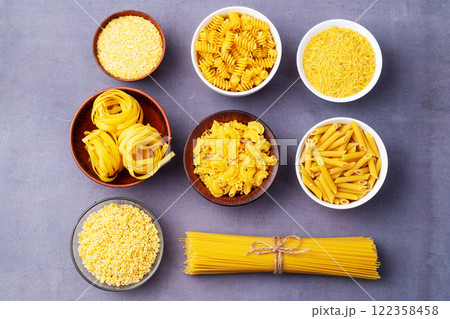 Assorted Uncooked Pasta in Bowls on Wooden Table 122358458