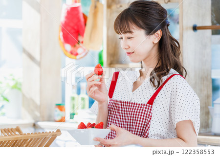 キッチンでイチゴをつまみ食いする女性 キッチンでイチゴをつまみ食いする女性 122358553