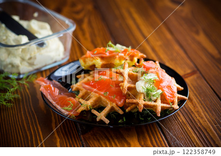 vegetable potato waffles with spread and lightly salted red fish, in a plate on a wooden table 122358749