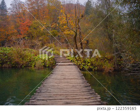 Wooden walkpath in Plitvice National Park. Splendid autumn in forest with pure water lake. Picturesque landscape of Croatia, Europe. Beauty of nature concept background. 122359165