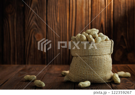 unshelled peanuts in sack on table 122359267
