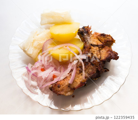 Dish of fried pork ribs, rice, potatoes, sweet potato and pickled onions 122359435