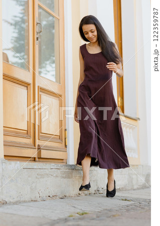 young African American woman in brown dress poses in park. happy female model at sunset in summer young African American woman in brown dress poses in park. happy female model at sunset in summer 122359787