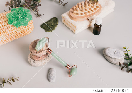 Jade roller for massage, pebbles and spa items on table Jade roller for massage, pebbles and spa items on table 122361054