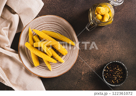 Canned mini corn cobs on a plate on a table top view Canned mini corn cobs on a plate on a table top view 122361072