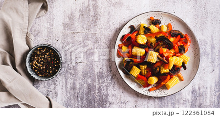 Vegetarian salad with corn cobs, mushrooms and peppers on a plate top view web banner 122361084