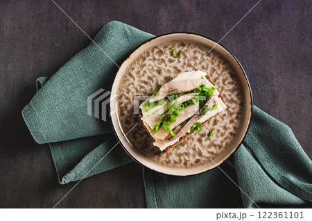 Close up of open sandwich on rye bread with butter and salted herring on a plate top view 122361101