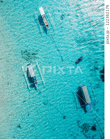 Boats at anchor in transparent blue ocean on Bali island. Aerial view. Boats at anchor in transparent blue ocean on Bali island. Aerial view. 122362176