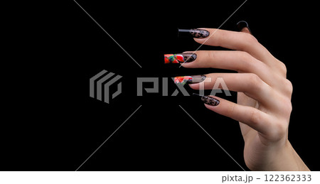 Hand with a beautiful manicure on a black background. Nail design. Extended nails. Hand with a beautiful manicure on a black background. Nail design. Extended nails. 122362333