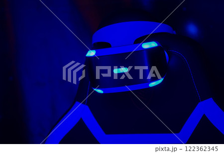 The PS VR headset is glowing on a dark blue background. 122362345