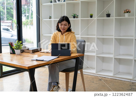 Intelligent young woman having online lessons on laptop, drinking coffee and taking notes, Intelligent young woman having online lessons on laptop, drinking coffee and taking notes, 122362487