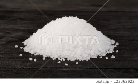 A pile of coarse table salt on a wooden table. A pile of coarse table salt on a wooden table. 122362922