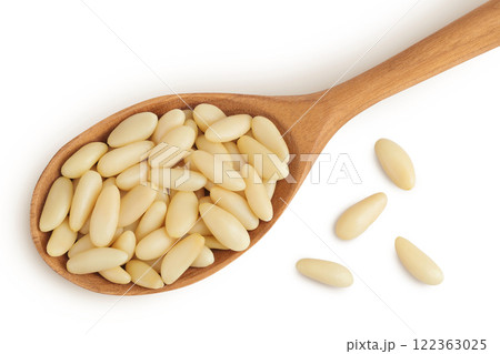 Shelled European pine nuts in wooden spoon isolated on white background with full depth of field. Top view. Flat lay 122363025