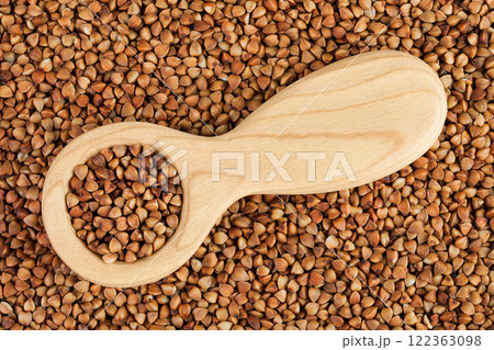 Raw buckwheat in wooden spoon as a background. Top view. Flat lay 122363098