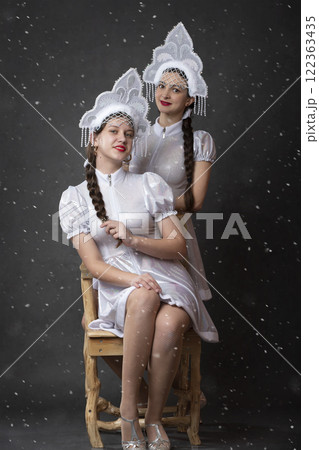 Two Russian Girls in a Snow Maiden costume posing on a gray background. 122363435