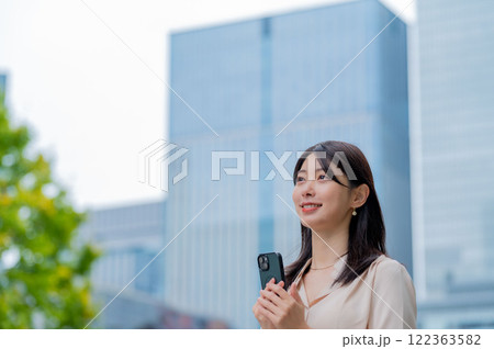 ビルを背景にスマホを持つ日本人女性 ビルを背景にスマホを持つ日本人女性 122363582