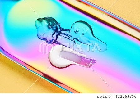 A drop of cosmetic serum, cream and gel on a multicolored background in shades of blue and lilac. 122363856
