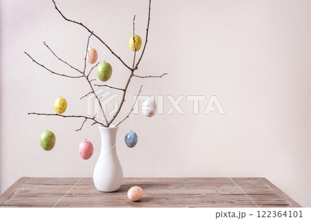 Painted Easter eggs on twig in vase 122364101