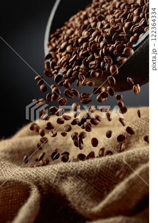 Freshly roasted coffee beans are poured into a bag. Freshly roasted coffee beans are poured into a bag. 122364334