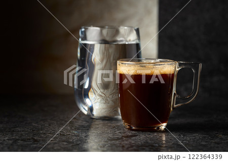 Espresso and glass of cold water on a black background. Espresso and glass of cold water on a black background. 122364339