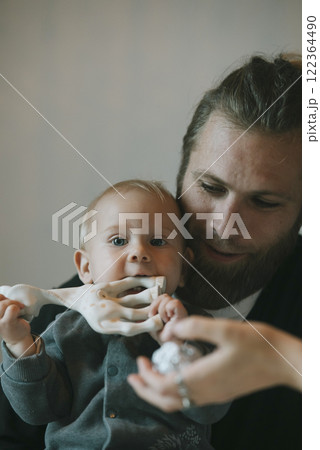 A Whimsical, Joyful Moment Between a Father and His Baby with a Unique Toy for Playtime A Whimsical, Joyful Moment Between a Father and His Baby with a Unique Toy for Playtime 122364490