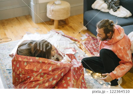 This is a candid moment capturing the holiday gift wrapping fun and joy of the season 122364510