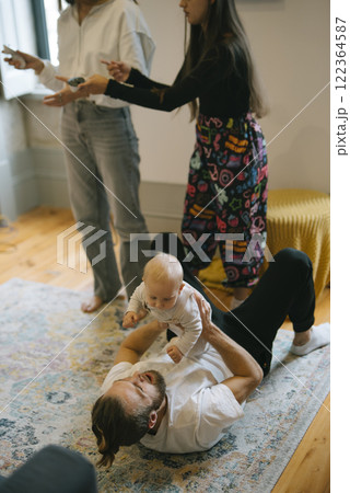 Engaging and Joyful Family Interaction with a Baby Laughing Happily on the Soft Rug 122364587