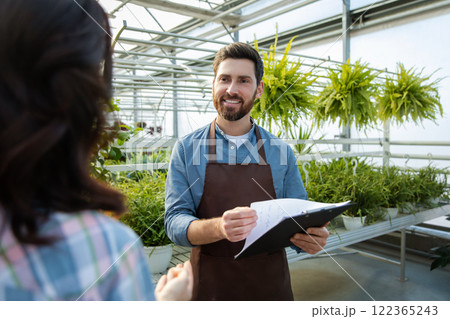 Two professionals talking in the greenhouse discussing plant cultivation Two professionals talking in the greenhouse discussing plant cultivation 122365243
