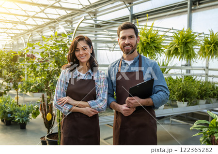 Two workers in a greenhouse looking positive and contented 122365282