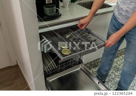 Man putting dishes in dishwasher 122365284