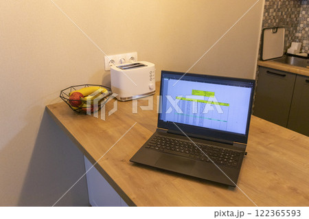Laptop on the kitchen counter top with an excel sheet on computer screen showing bank loan amortization table. Laptop on the kitchen counter top with an excel sheet on computer screen showing bank loan amortization table. 122365593