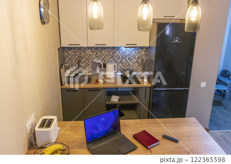 Laptop on the kitchen counter top with an excel sheet on computer screen showing bank loan amortization table. Laptop on the kitchen counter top with an excel sheet on computer screen showing bank loan amortization table. 122365598