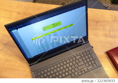 Laptop on the kitchen counter top with an excel sheet on computer screen showing bank loan amortization table. Laptop on the kitchen counter top with an excel sheet on computer screen showing bank loan amortization table. 122365633