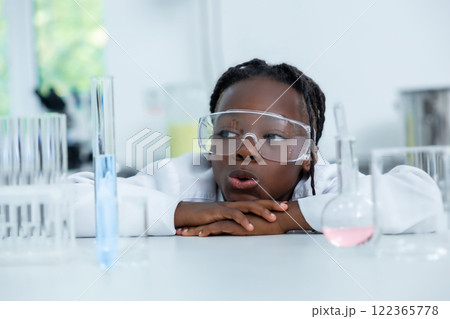 Female chemist in lab testing liquid in flask and tube conducting scientific experiments Female chemist in lab testing liquid in flask and tube conducting scientific experiments 122365778