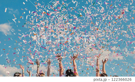 High school graduates joyfully tossing colorful confetti in the air to celebrate their summer graduation 122366026