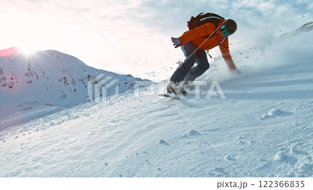 Snowboard rider riding down fresh powder during sunny day , Alpine scenery Snowboard rider riding down fresh powder during sunny day , Alpine scenery 122366835
