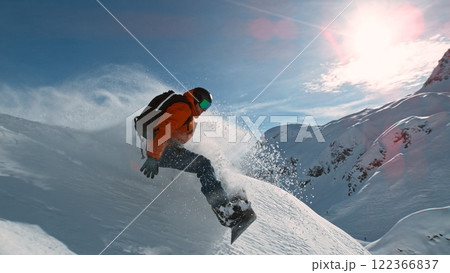 Snowboard rider riding down fresh powder during sunny day , Alpine scenery Snowboard rider riding down fresh powder during sunny day , Alpine scenery 122366837