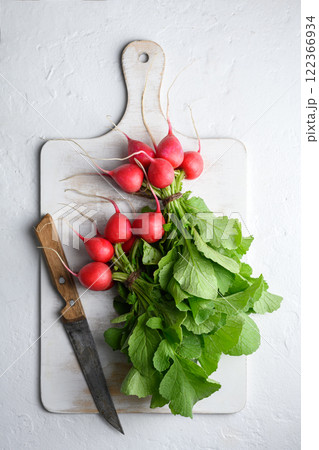 Two bunch of red radish on white cutting board Two bunch of red radish on white cutting board 122366934
