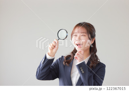 ルーペを覗いて何かを発見したビジネスウーマン_1 122367015