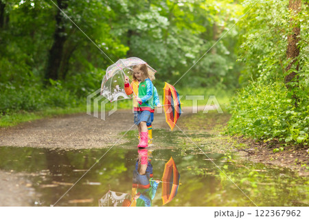Kids playing in the rain with umbrella 122367962