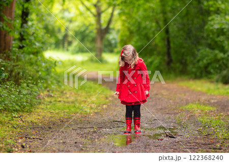Little girl walking in the rain 122368240