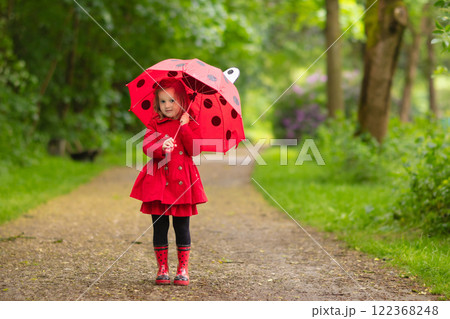 Little girl walking in the rain 122368248