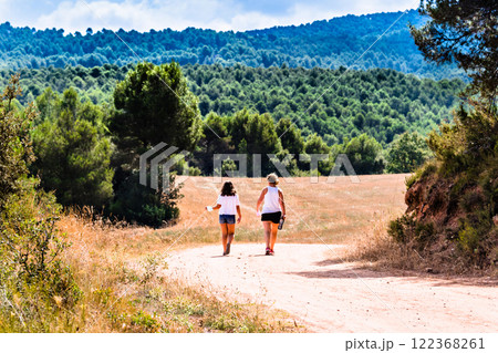 Mother with her daughter walking through nature along a forest path in Anoia, Barcelona Mother with her daughter walking through nature along a forest path in Anoia, Barcelona 122368261